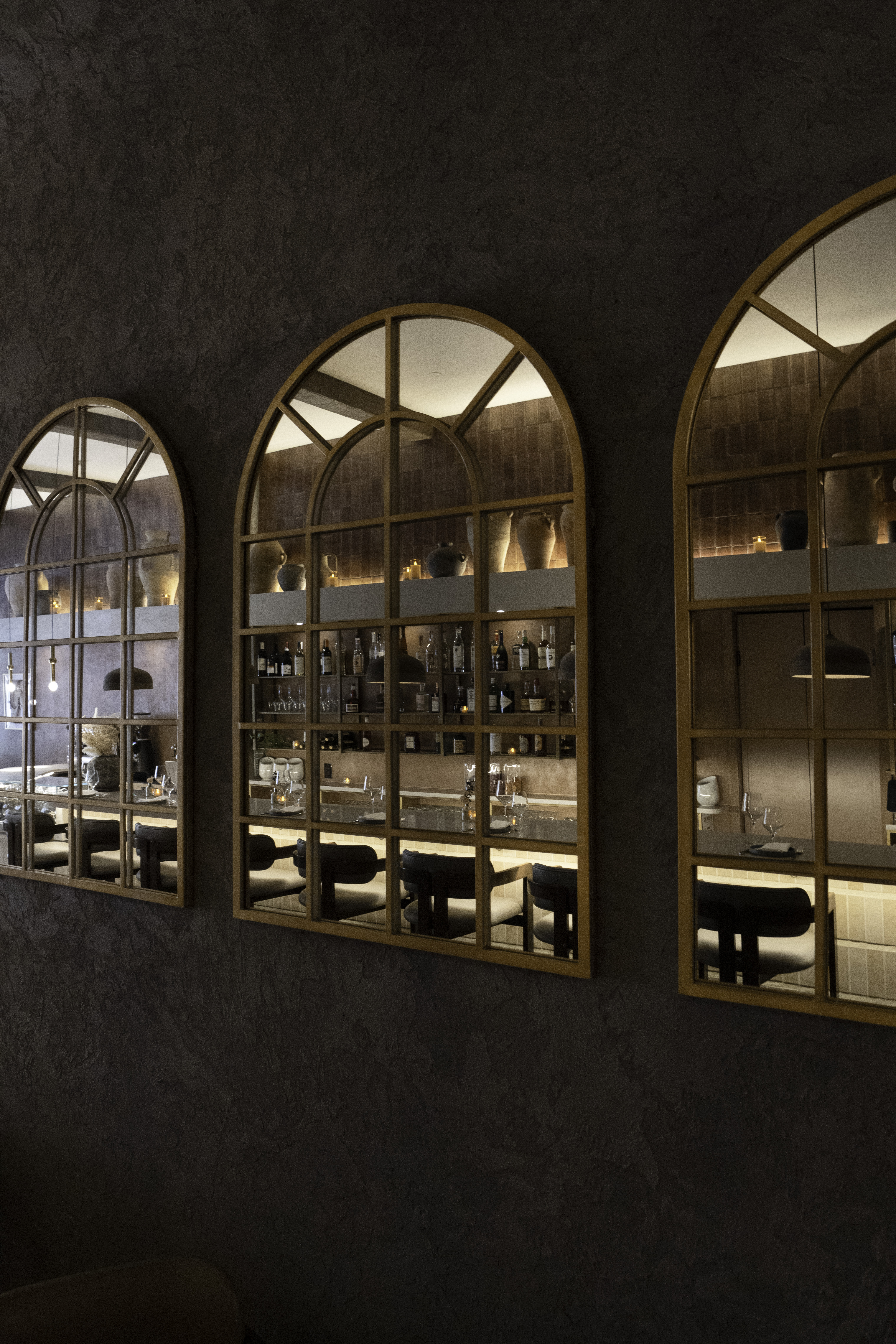 Reverie — arched mirrors reflecting the bar